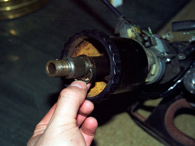 A split cone is located in a recess in the inner shaft. The central nut clamps the steering wheel boss against the cone.